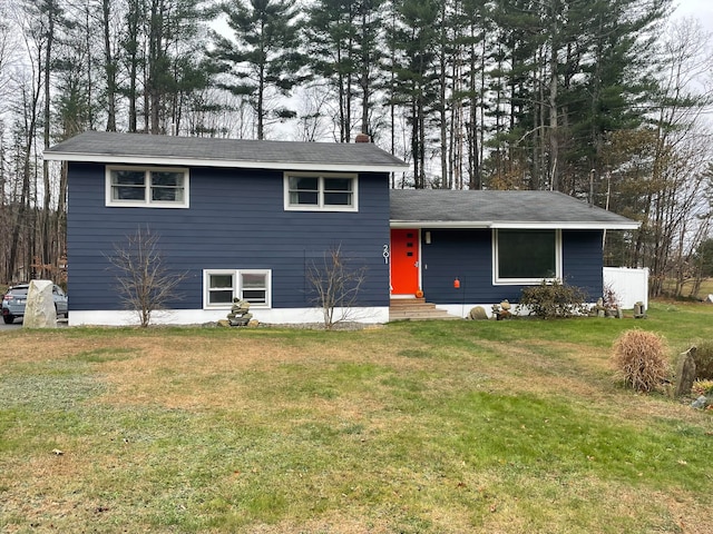 tri-level home with entry steps, a front lawn, and a chimney