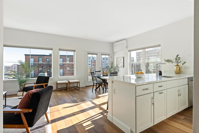 kitchen with white cabinetry, light hardwood / wood-style floors, a healthy amount of sunlight, and sink