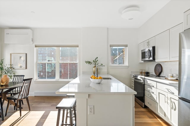 kitchen with plenty of natural light, light hardwood / wood-style flooring, white cabinets, and stainless steel appliances