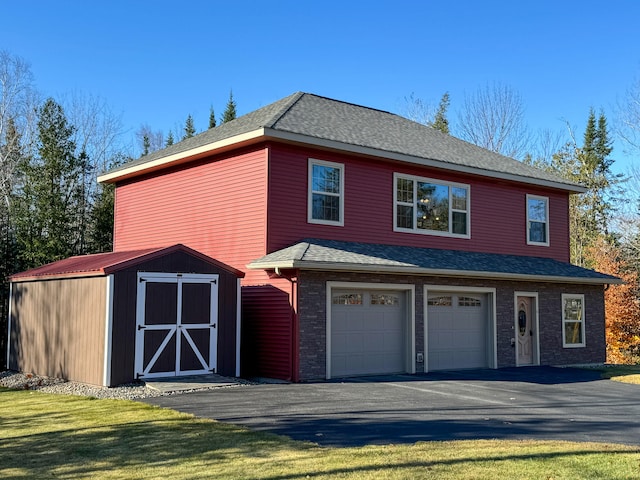 exterior space with a garage, a shed, and a front lawn