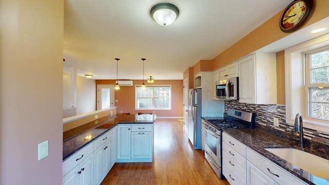 kitchen with white cabinetry, appliances with stainless steel finishes, and decorative light fixtures