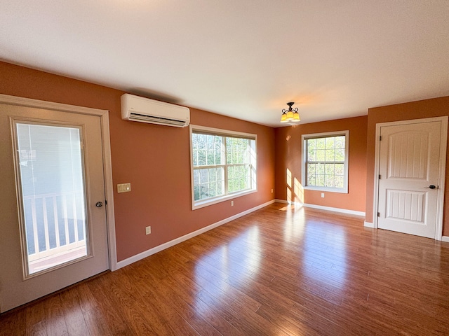 unfurnished room featuring hardwood / wood-style flooring and an AC wall unit