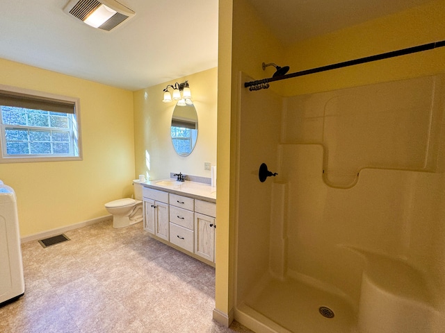 bathroom with a shower, vanity, toilet, and washer / clothes dryer