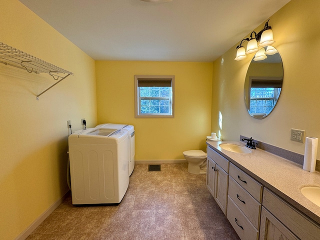 bathroom featuring vanity, toilet, and washing machine and clothes dryer