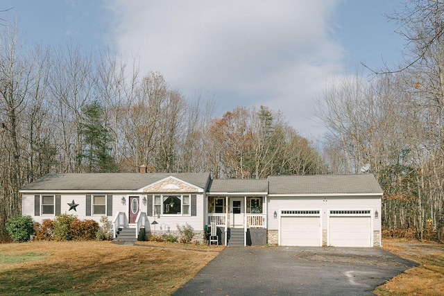 view of front of home with a garage, a porch, and a front yard