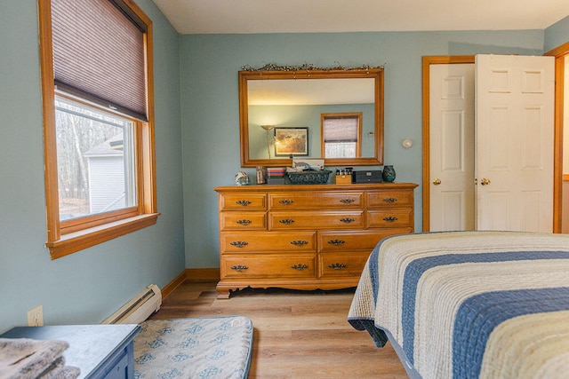 bedroom featuring light hardwood / wood-style flooring and a baseboard heating unit