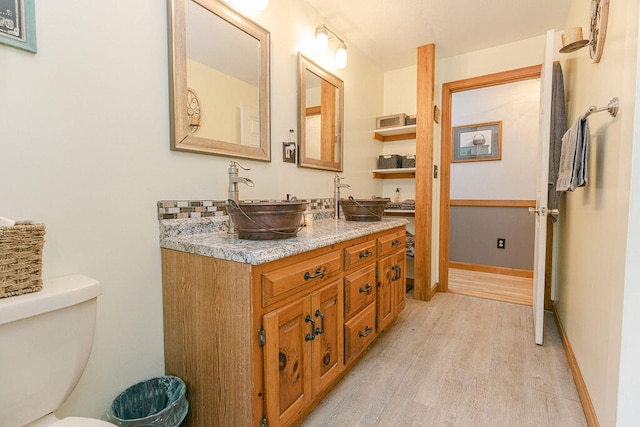 bathroom with wood-type flooring, vanity, and toilet