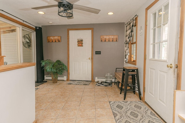 tiled entrance foyer with ceiling fan and baseboard heating