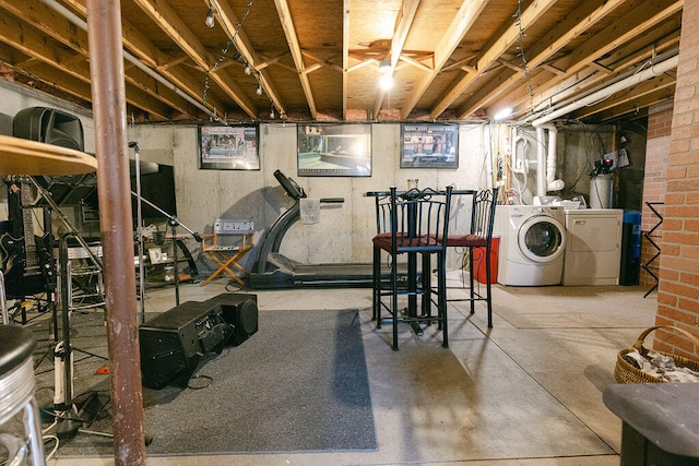 exercise area featuring washing machine and clothes dryer and concrete flooring