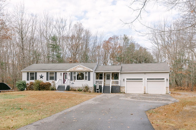 view of front of property with a garage, covered porch, and a front lawn