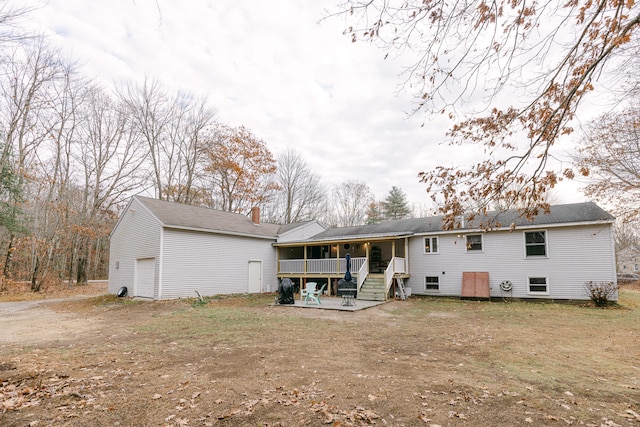 rear view of house with a garage and a wooden deck