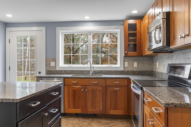610 W Neck Rd, Nobleboro, ME 04555 - kitchen featuring appliances with stainless steel finishes, dark stone counters, tasteful backsplash, brown cabinetry, and recessed lighting