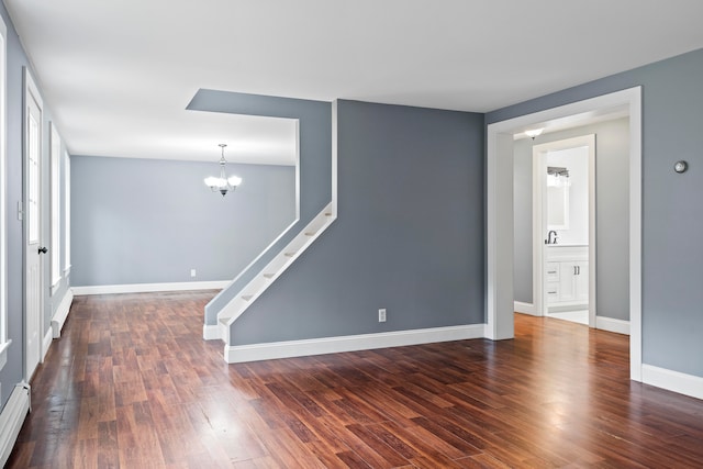 unfurnished room with a baseboard radiator, dark hardwood / wood-style floors, and a chandelier