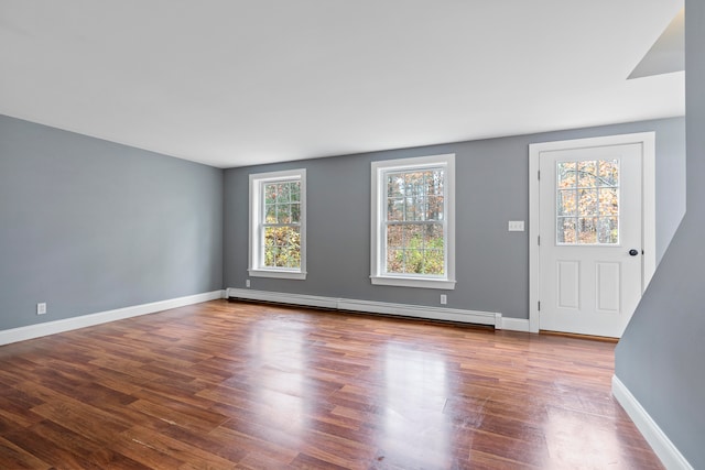 interior space featuring baseboard heating and wood-type flooring