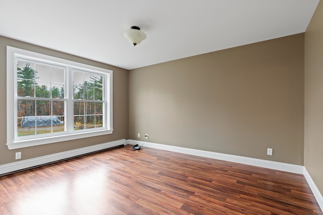 spare room with hardwood / wood-style flooring and a baseboard radiator