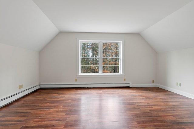 additional living space with vaulted ceiling, dark hardwood / wood-style floors, and a baseboard heating unit