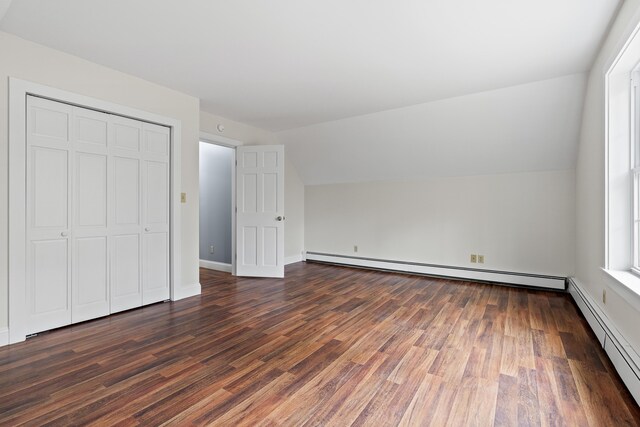 610 W Neck Rd, Nobleboro, ME 04555 - unfurnished bedroom with vaulted ceiling, a baseboard radiator, dark wood-style flooring, and a closet