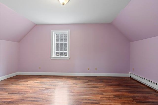 bonus room featuring dark wood-type flooring, a baseboard heating unit, and lofted ceiling