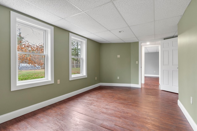 unfurnished room with a drop ceiling and hardwood / wood-style floors