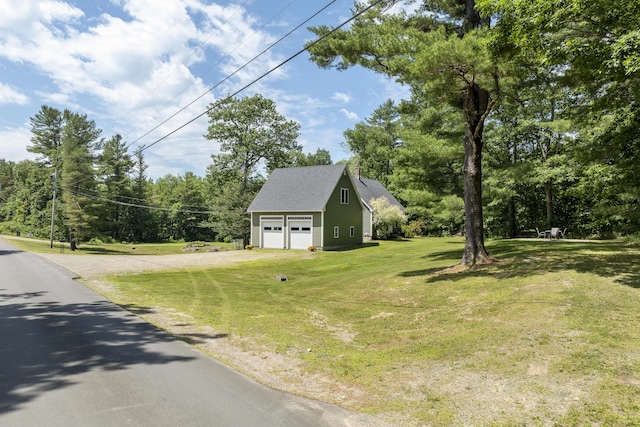 610 W Neck Rd, Nobleboro, ME 04555 - view of side of home featuring a detached garage, an outdoor structure, a yard, and view of wooded area