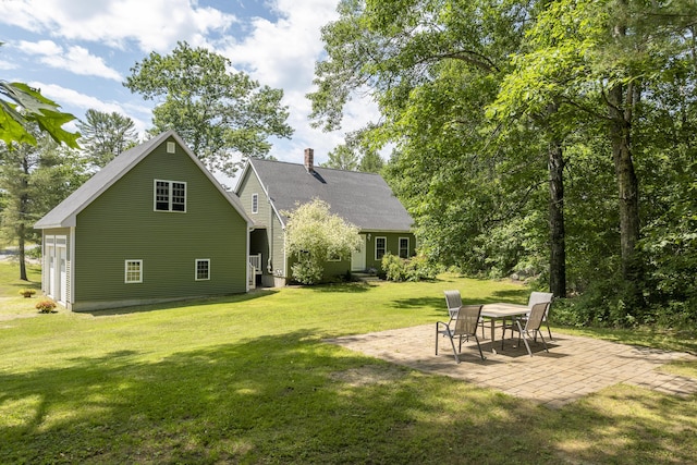 610 W Neck Rd, Nobleboro, ME 04555 - back of property featuring a patio area, a yard, and a chimney