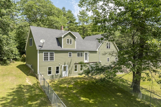 610 W Neck Rd, Nobleboro, ME 04555 - back of property featuring view of wooded area, a shingled roof, and a chimney