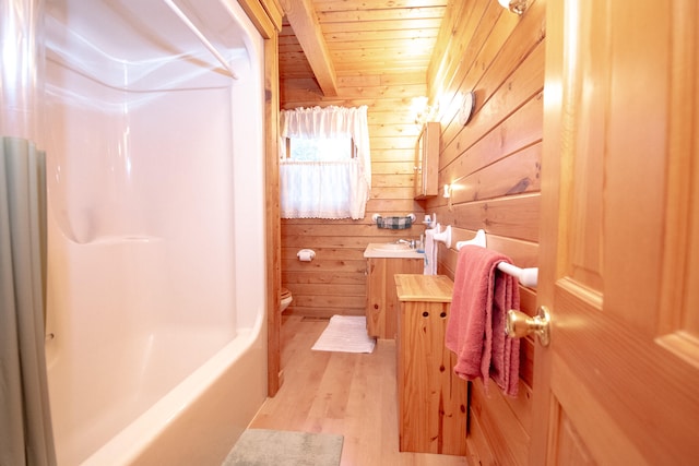 full bathroom with vanity, toilet, wood ceiling, and wooden walls