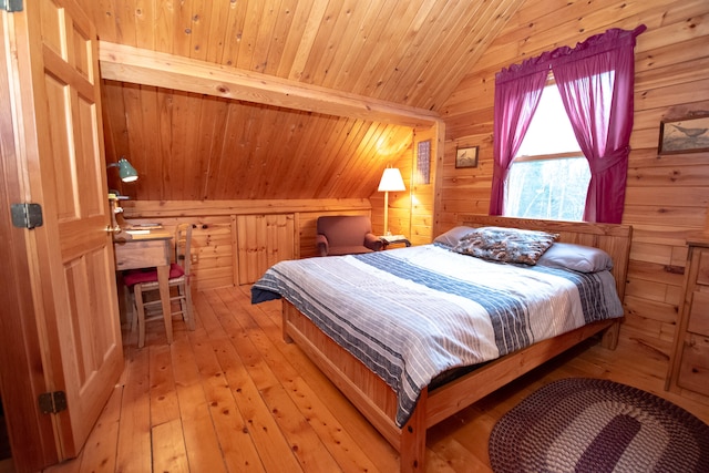 bedroom with wooden ceiling, vaulted ceiling, light hardwood / wood-style floors, and wood walls