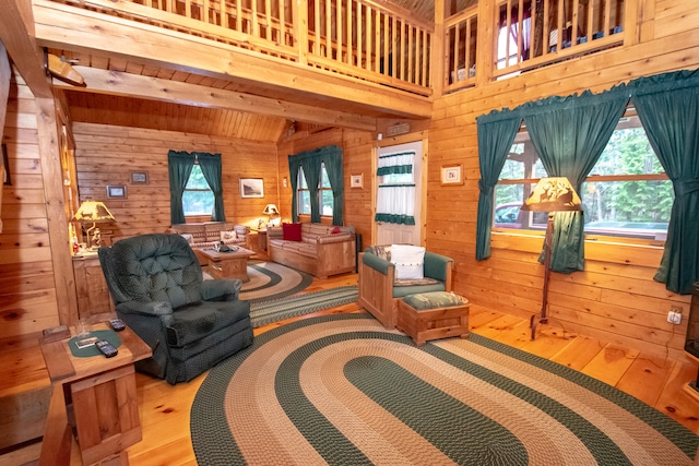 living room with light hardwood / wood-style floors, a healthy amount of sunlight, and wooden walls