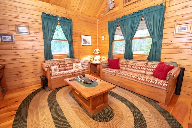 living room with wood walls, lofted ceiling, a healthy amount of sunlight, and wooden ceiling