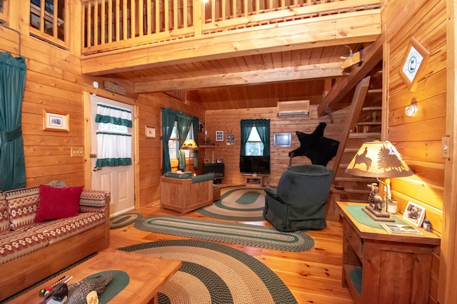 living room featuring beamed ceiling, wooden walls, and hardwood / wood-style flooring