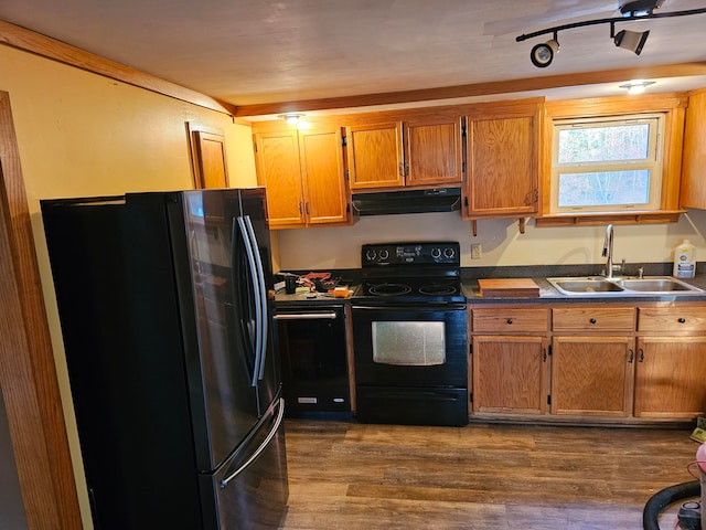 kitchen with dark wood-type flooring, black appliances, and sink