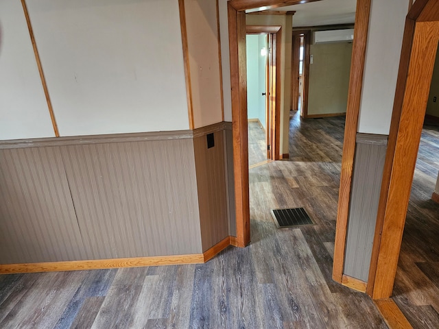 hall with a wall mounted AC and dark hardwood / wood-style floors