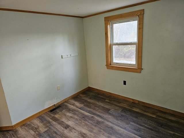 empty room featuring dark wood-type flooring and crown molding