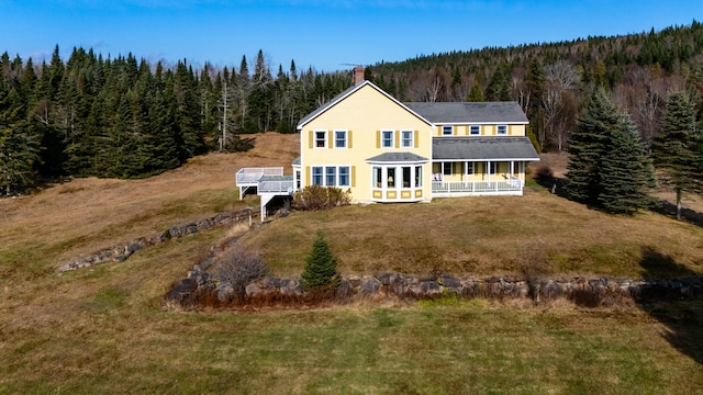 back of house featuring a lawn and a sunroom