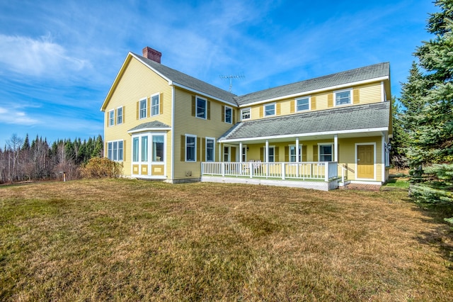 back of house featuring a yard and covered porch