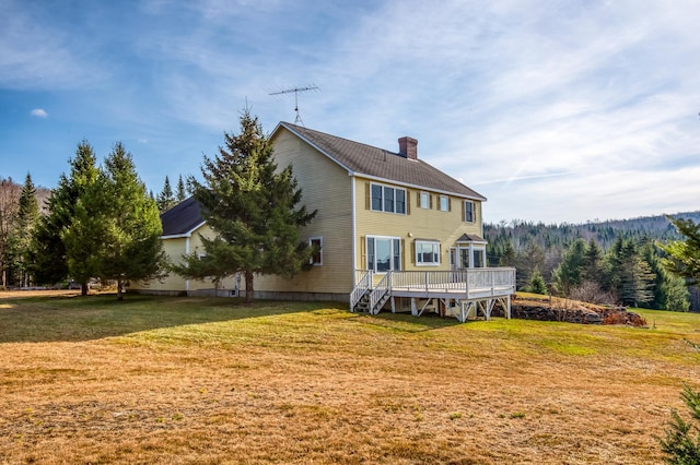 back of property featuring a yard and a deck