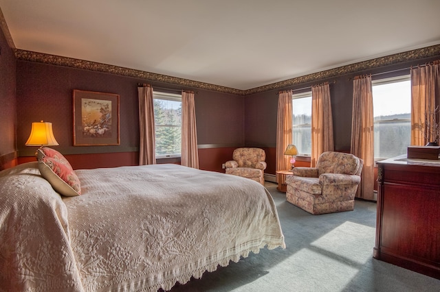 bedroom with baseboard heating and carpet