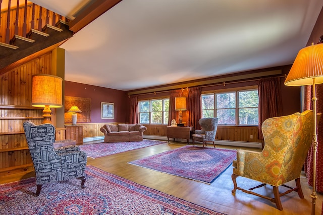 living room with a baseboard radiator, wood walls, and hardwood / wood-style flooring