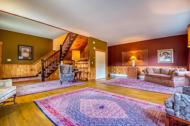 living room with wood walls, hardwood / wood-style floors, and a baseboard heating unit