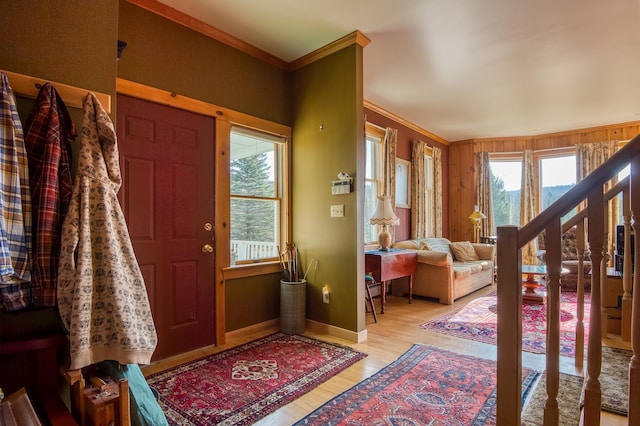 foyer entrance with light wood-type flooring and ornamental molding