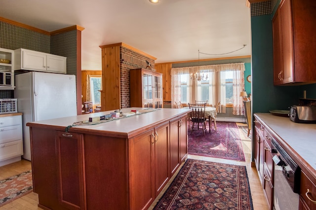 kitchen with baseboard heating, a chandelier, light hardwood / wood-style flooring, a kitchen island, and pendant lighting