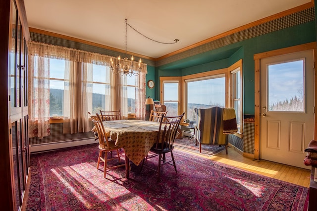 dining room with baseboard heating, hardwood / wood-style flooring, and an inviting chandelier