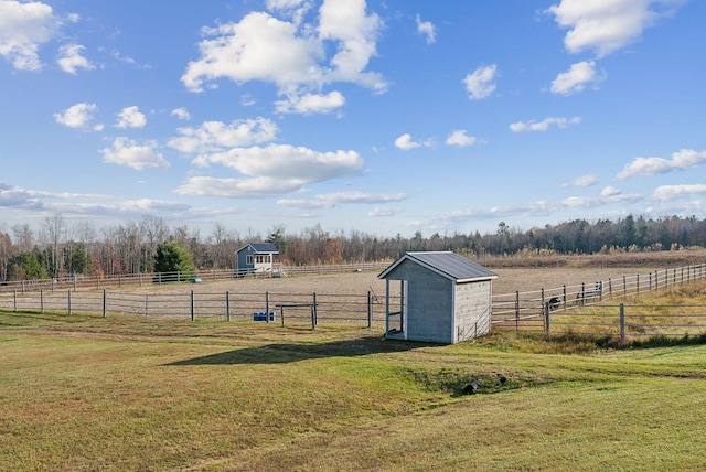 view of yard with a rural view and an outdoor structure