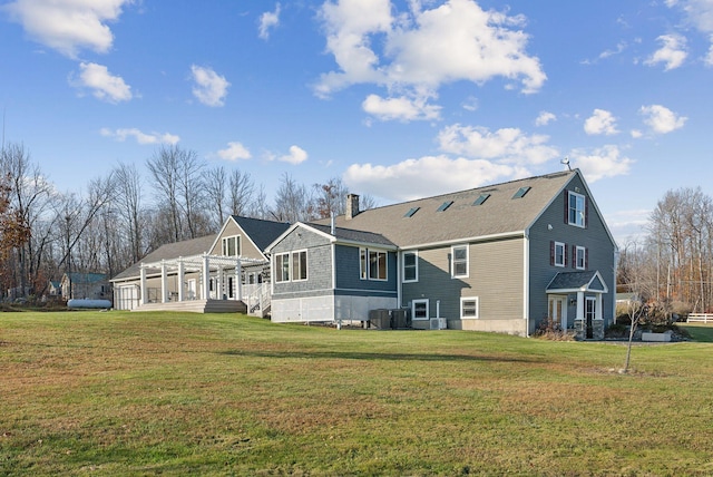 rear view of house with a yard and central AC unit