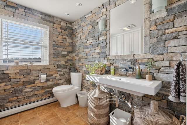 bathroom featuring toilet, baseboard heating, and sink