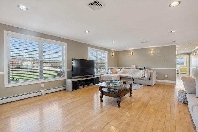 living room with light hardwood / wood-style floors, ornamental molding, and plenty of natural light