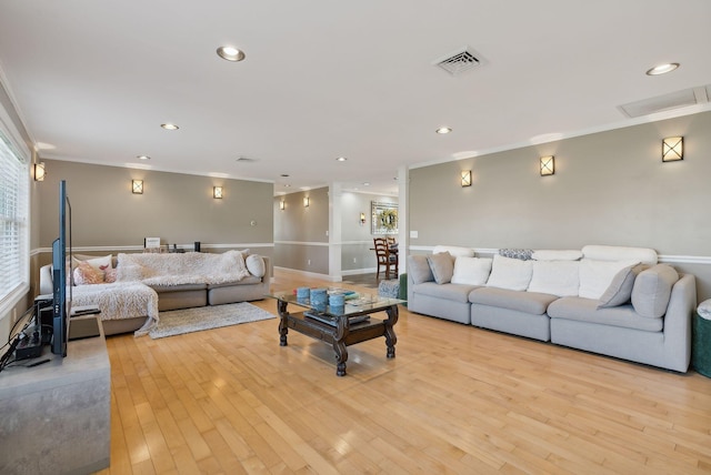 living room featuring light hardwood / wood-style floors and crown molding