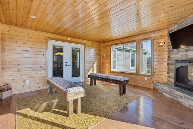 playroom with hardwood / wood-style floors, french doors, and wood walls