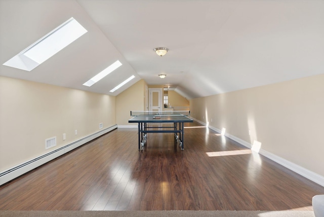 playroom featuring lofted ceiling with skylight, a baseboard radiator, and dark hardwood / wood-style flooring